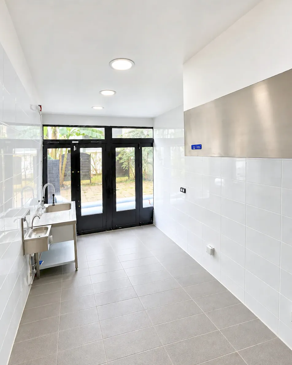 Laboratoire Hub Kitchen Porte de Clichy : baies vitrées, hotte inox, plonge et lave-mains