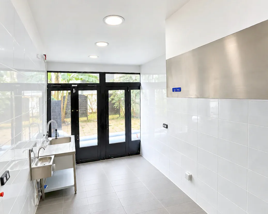 Laboratoire Hub Kitchen Porte de Clichy : baies vitrées, hotte inox, plonge et lave-mains