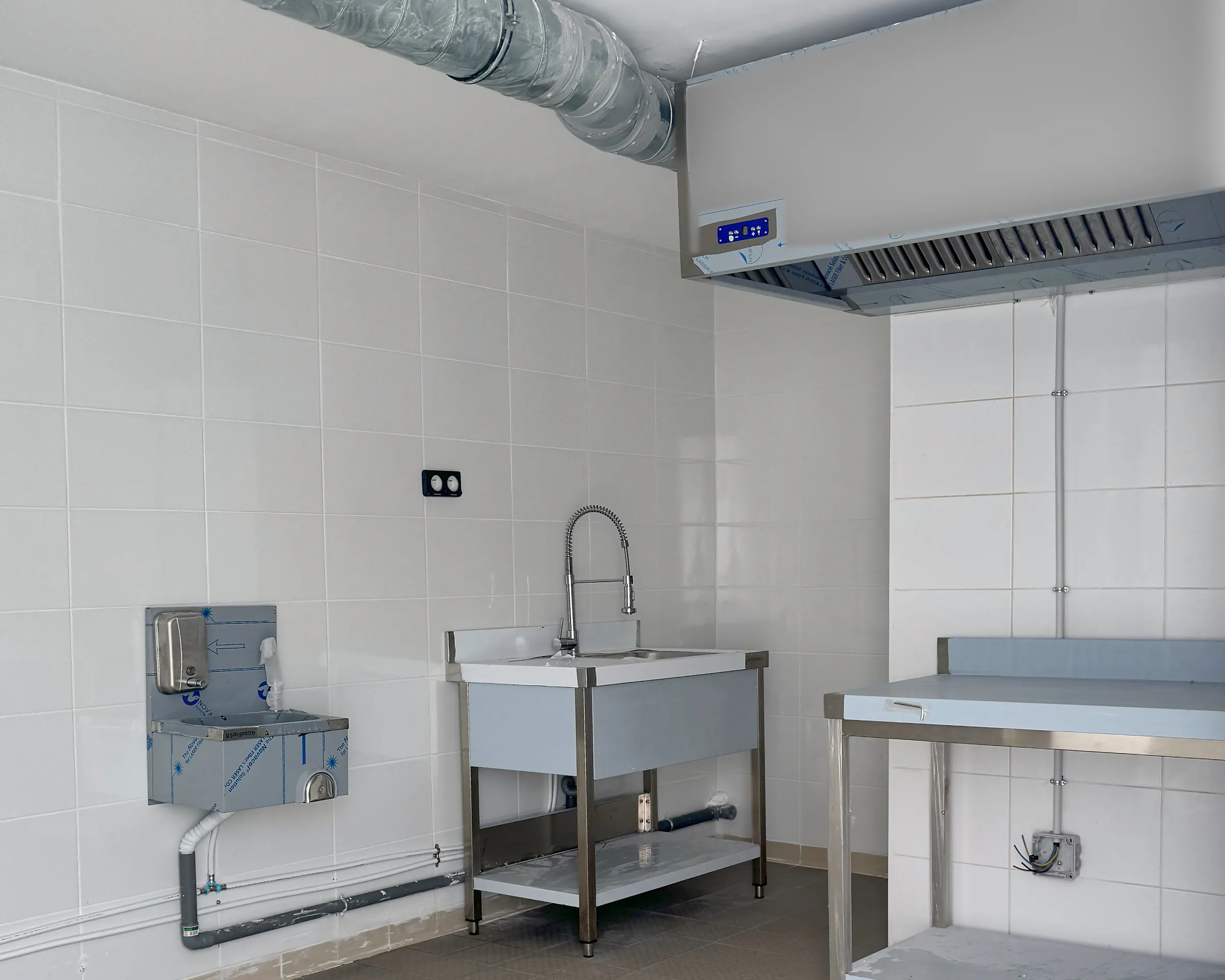 Laboratoire Hub Kitchen Porte de Gentilly : hotte et gaine d'extraction, lave-mains, plonge inox avec douchette et table inox