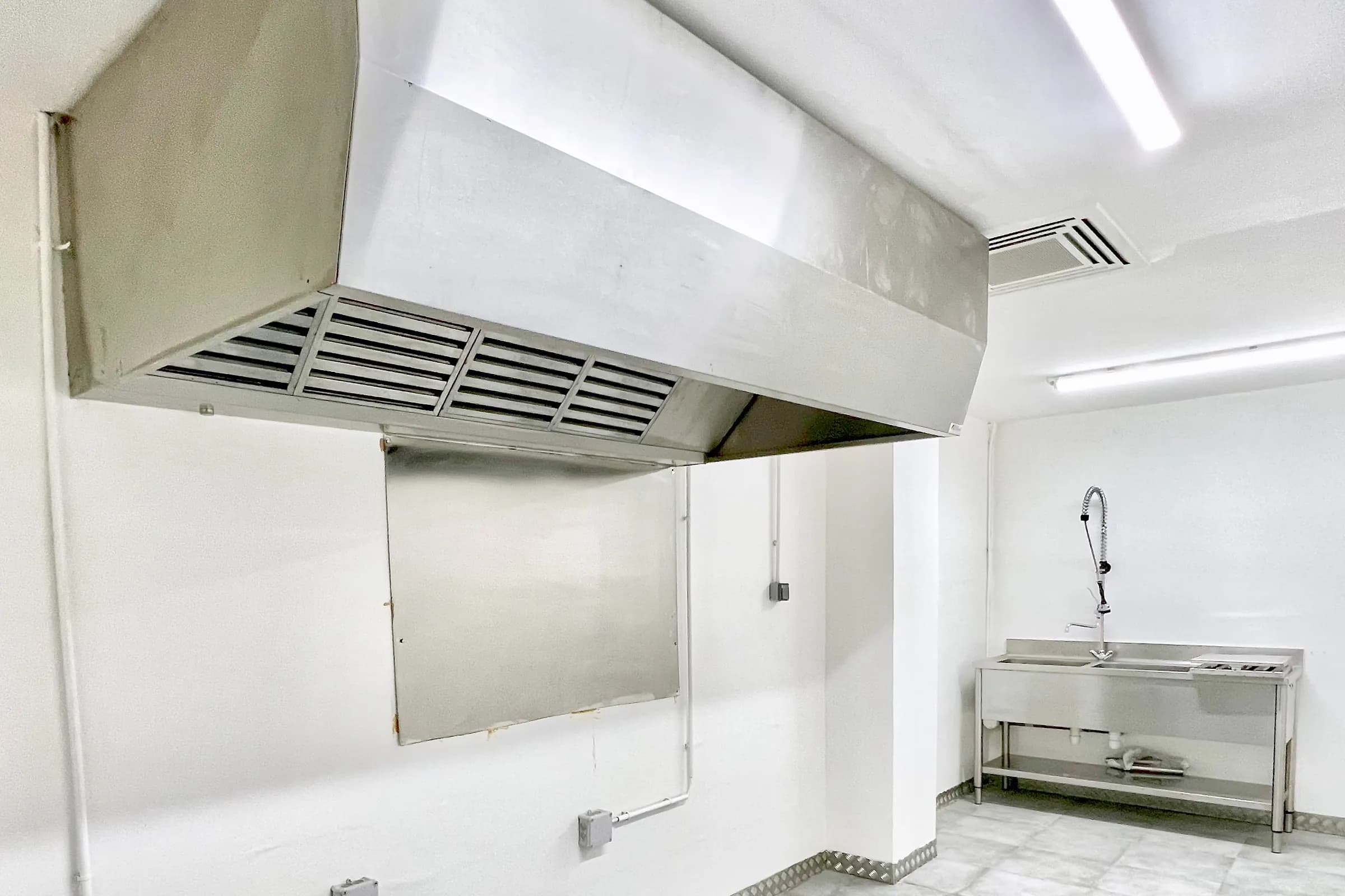 Laboratoire Hub Kitchen : hotte inox à filtres, crédence inox et plonge inox avec douchette (photo d'un autre site du réseau)
