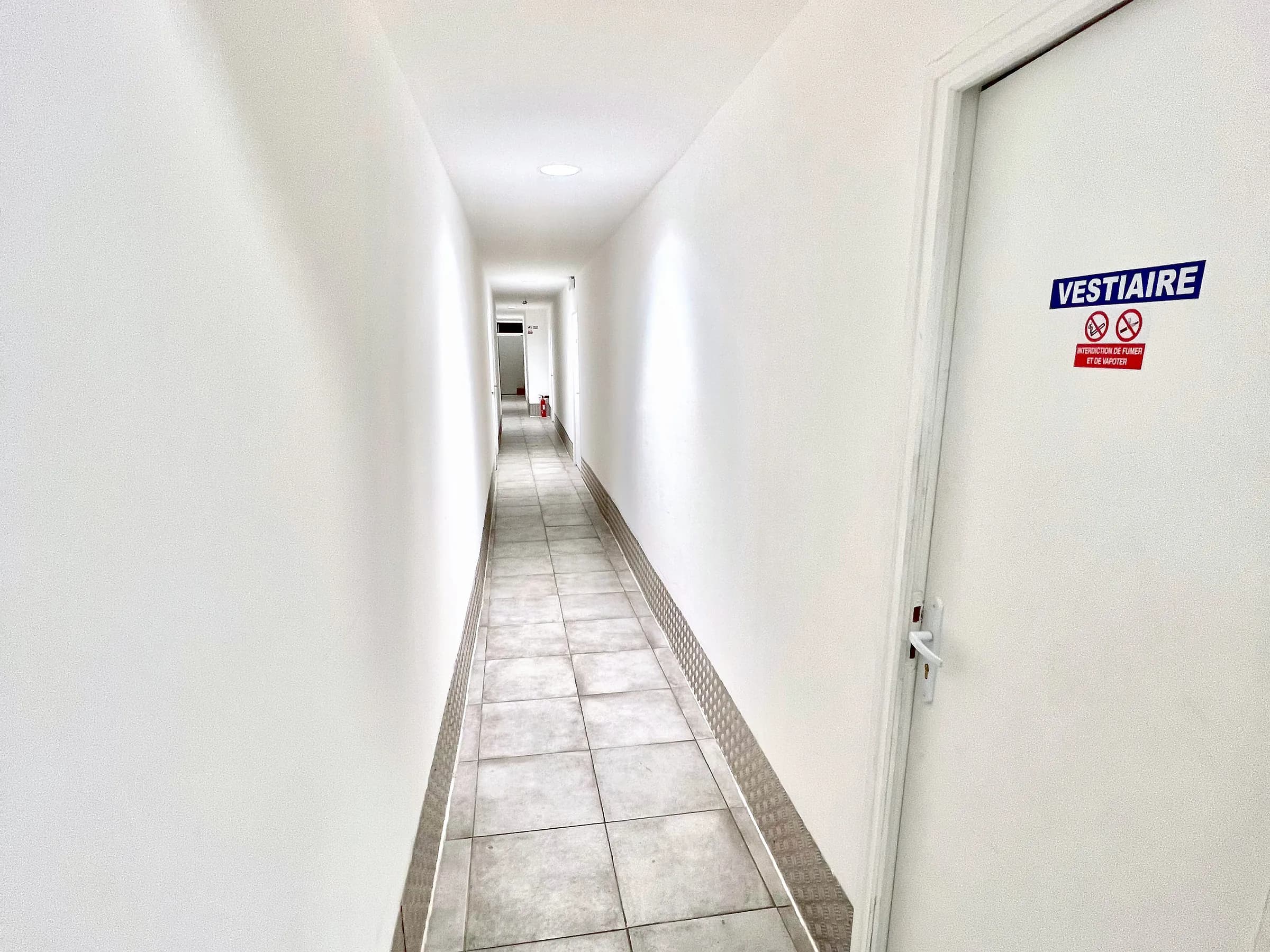 Couloir des parties communes d'un site Hub Kitchen et porte des vestiaires